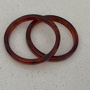Two bangle bracelets in brown looks great together. I’m not sure of the material
